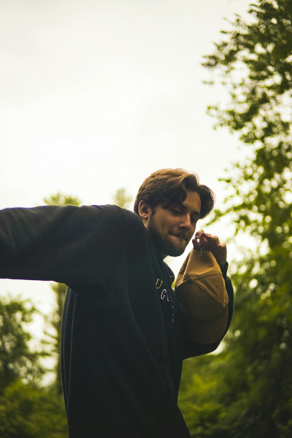 a man in a black jacket holding a yellow frisbee