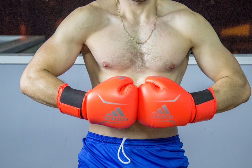 a man with no shirt wearing boxing gloves