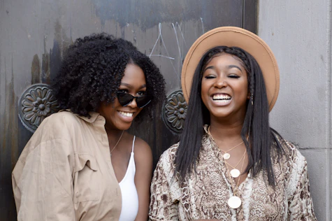 two women standing next to each other smiling