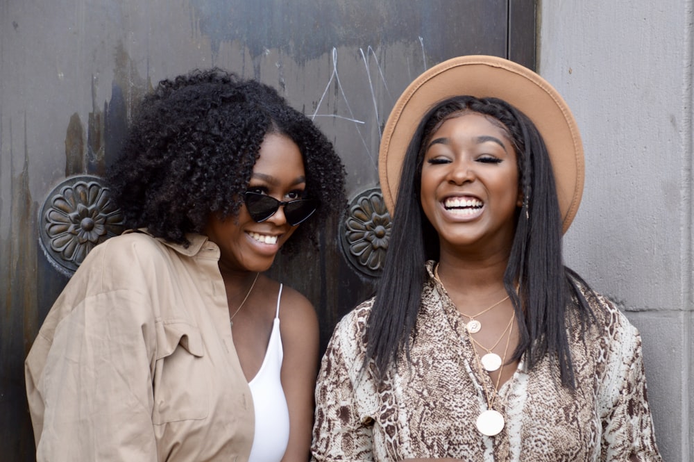 duas mulheres de pé uma ao lado da outra sorrindo