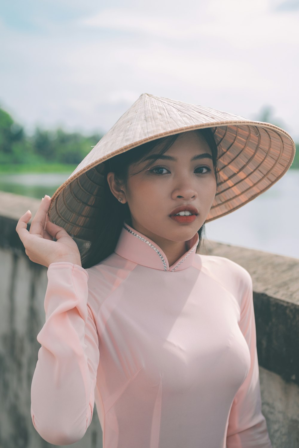 a woman wearing a hat and a pink shirt