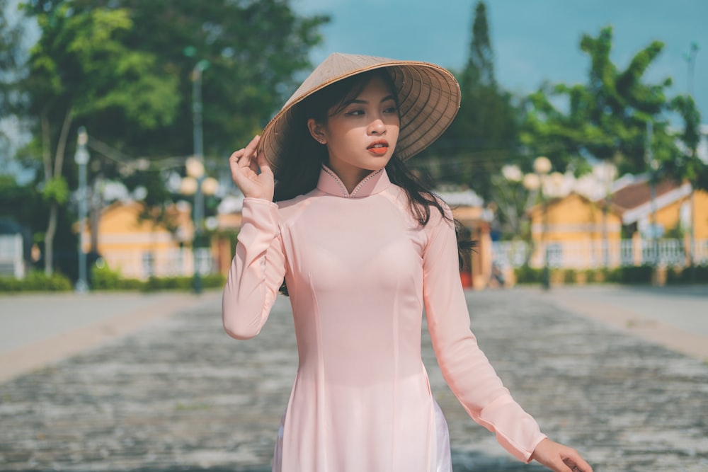 a woman in a pink dress and a hat