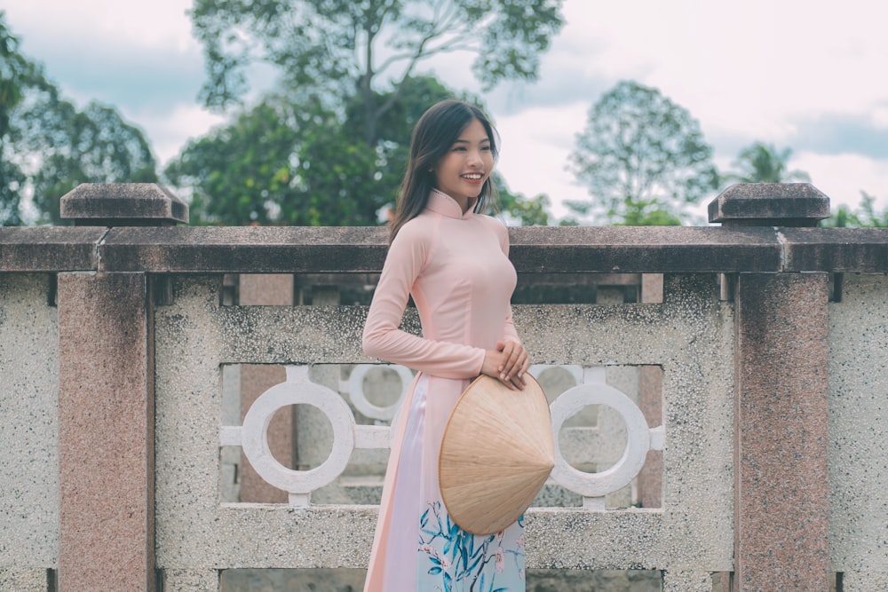 a woman in a long dress holding a large bag