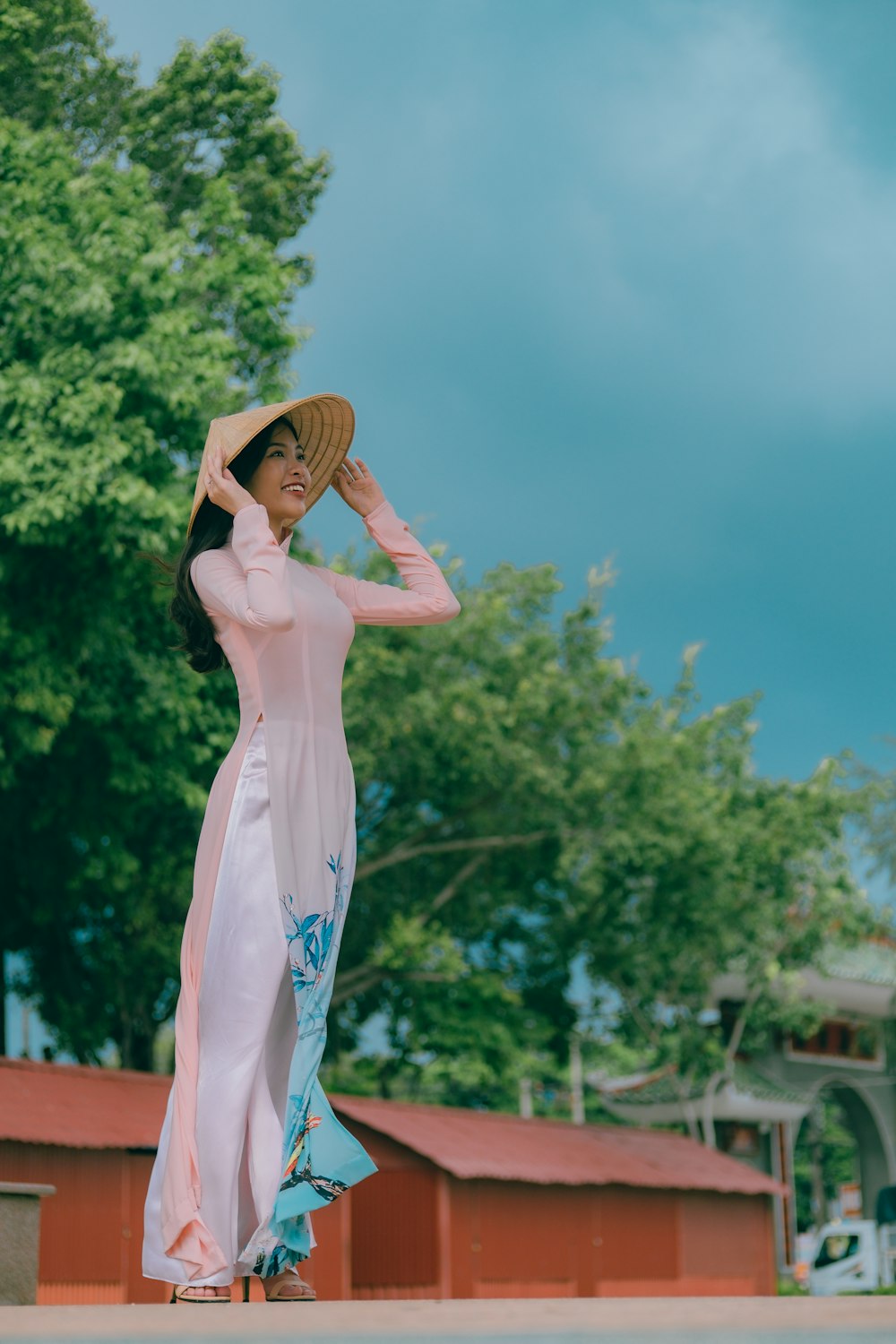 a woman in a pink dress and a straw hat