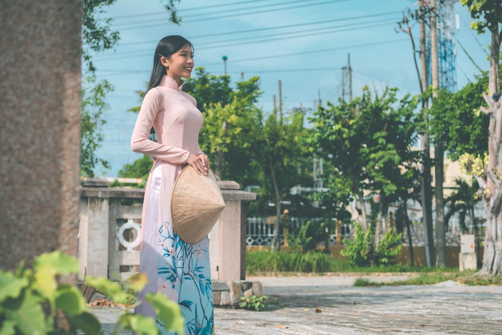 a woman in a pink top is holding a bag