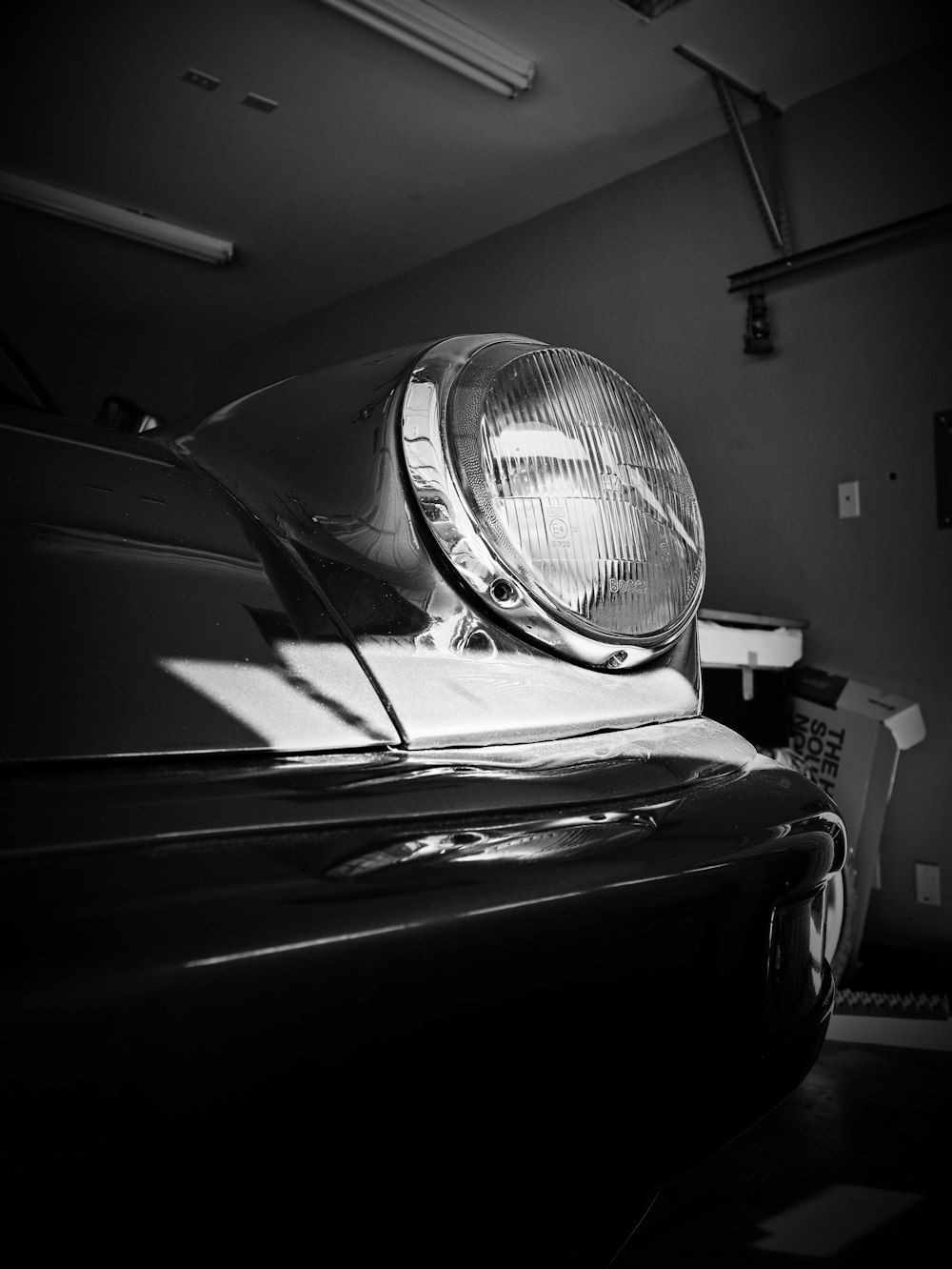 a black and white photo of a car headlight