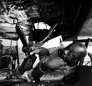 a black and white photo of a man working on a machine