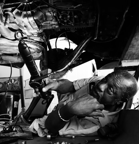 a black and white photo of a man working on a machine