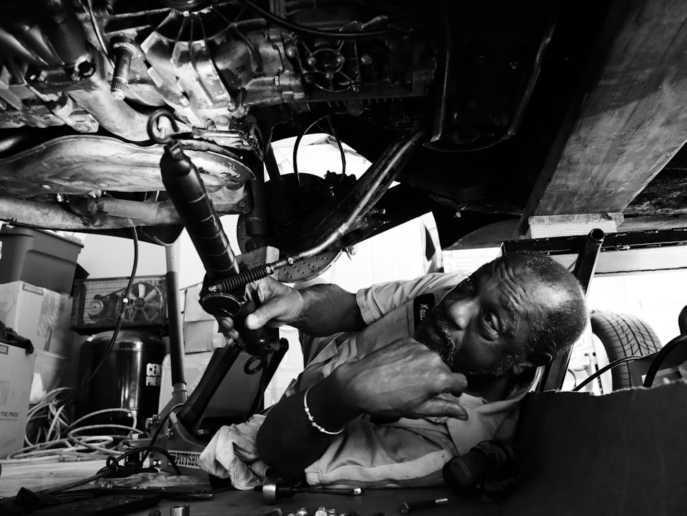Una foto in bianco e nero di un uomo che lavora su una macchina
