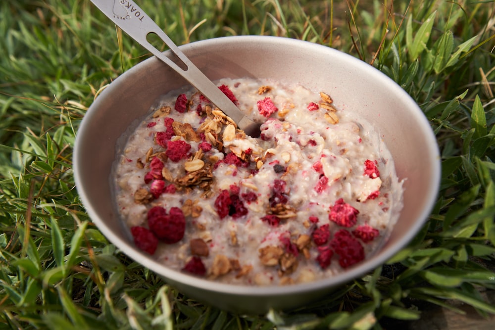 a bowl of oatmeal with raspberries and nuts