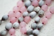 Close-up of premium beads in soft pastel colors with delicate daisy accents.
