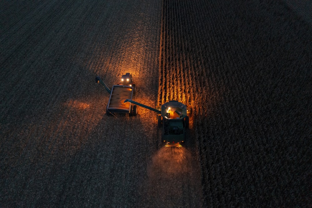 a tractor is driving through a field at night