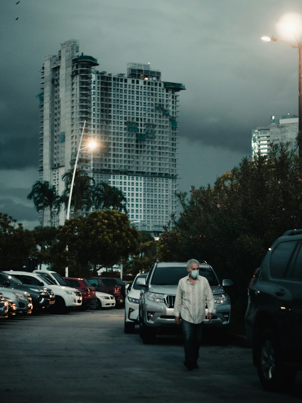 a man walking down a street next to parked cars