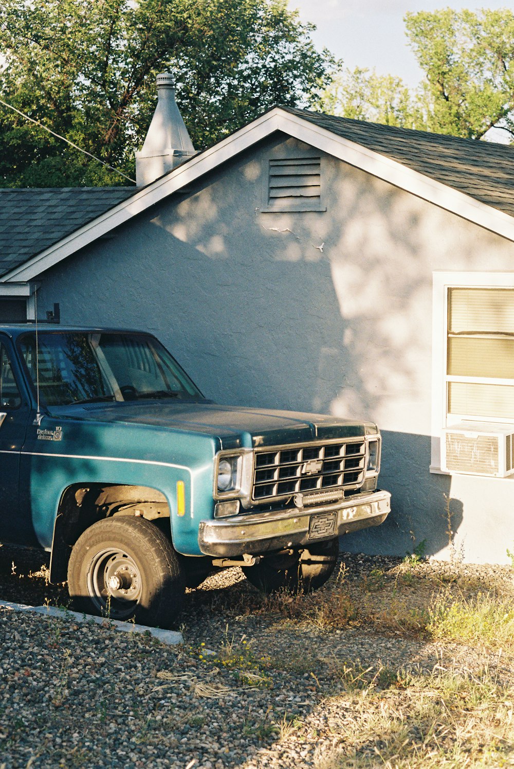 a blue pick up truck parked in front of a house