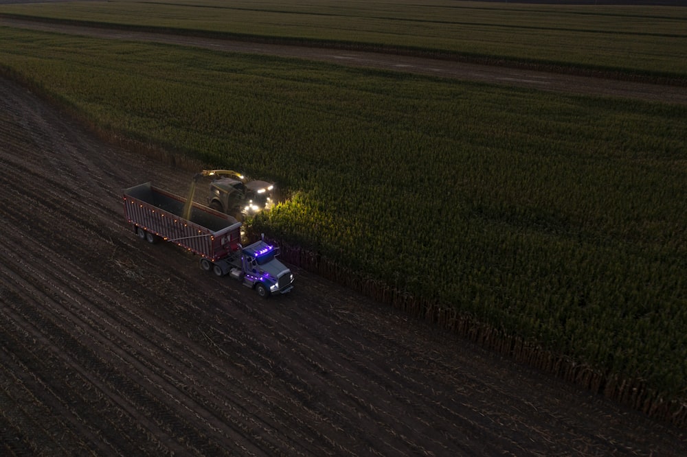 a tractor pulling a trailer behind it in a field