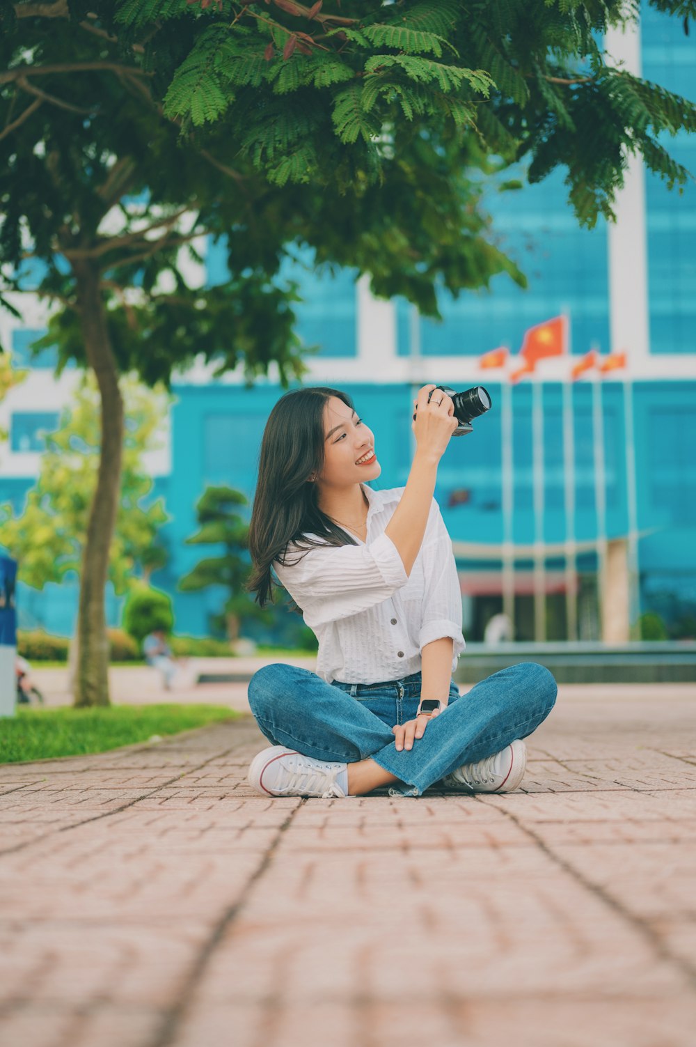 a woman sitting on the ground taking a picture