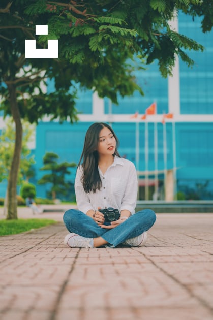 A woman sitting on the ground holding a purse photo – Free Woman Image on  Unsplash