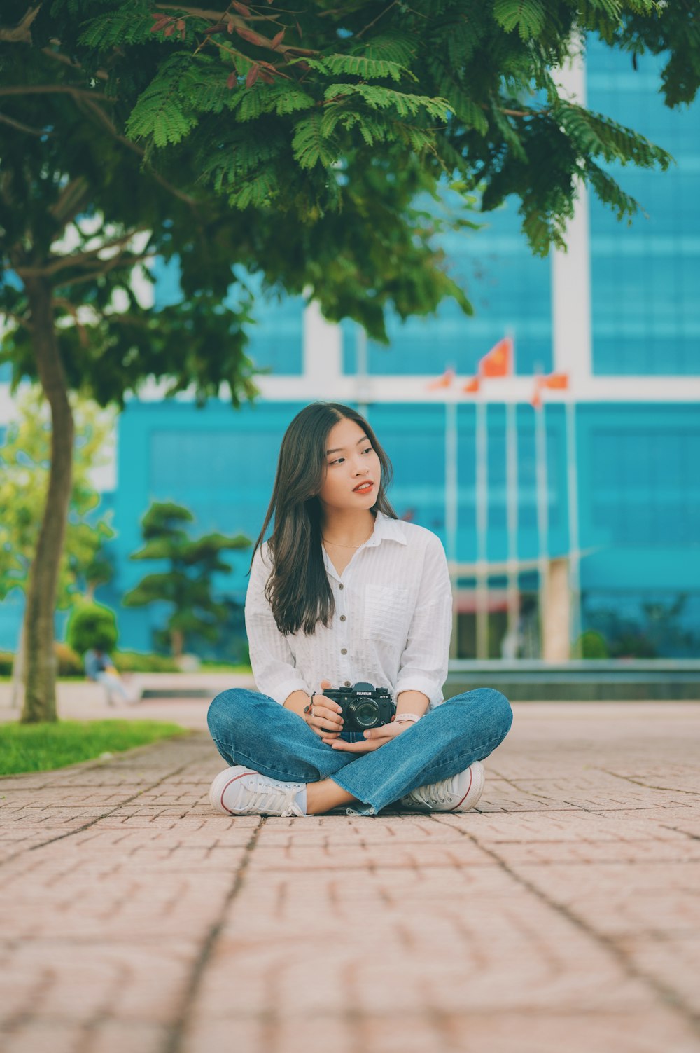 a woman sitting on the ground holding a camera