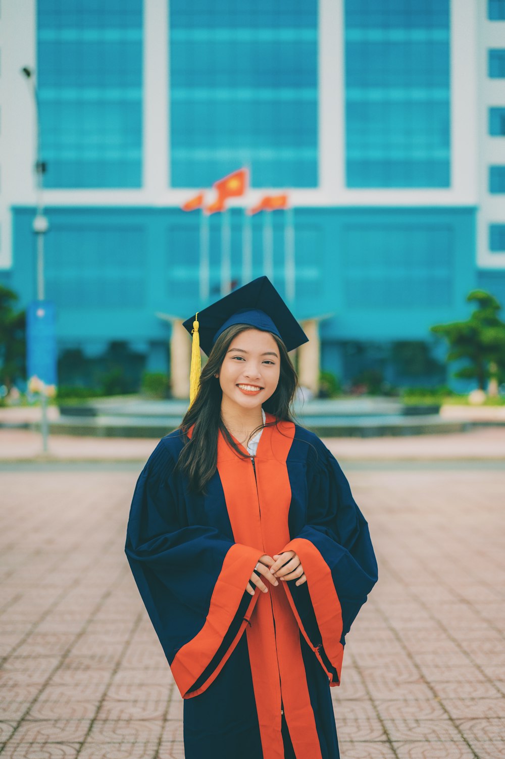 a woman in a graduation gown standing in front of a building