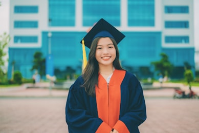 a woman in a graduation gown standing in front of a building