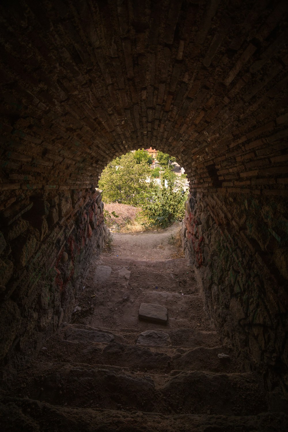 a stone tunnel with steps leading into the distance