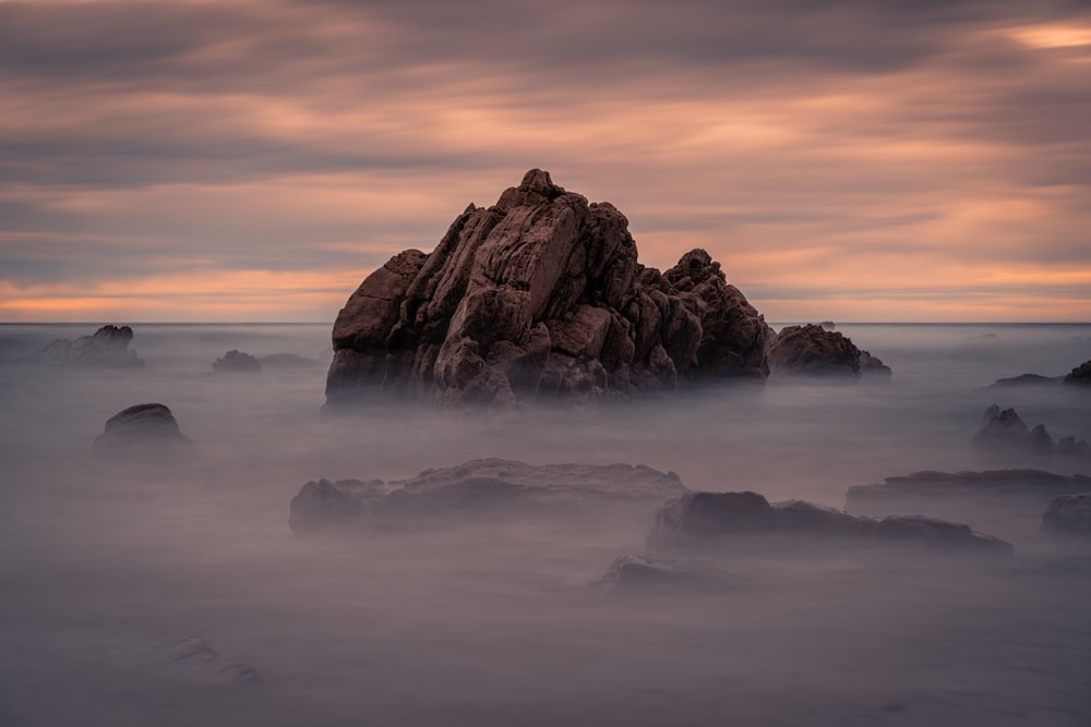 a large rock in the middle of a body of water