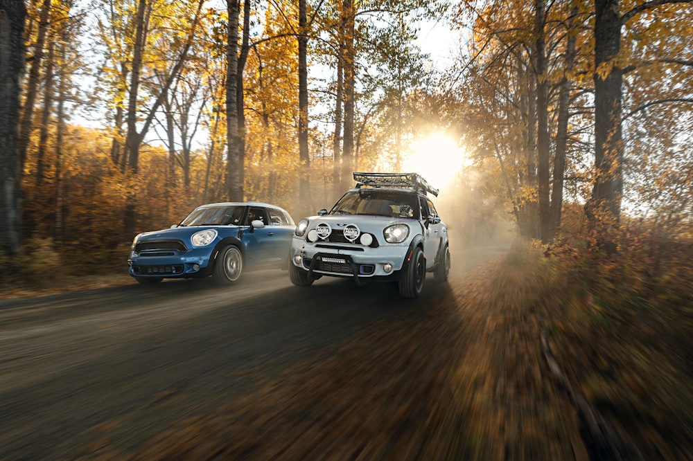 a couple of cars driving down a dirt road