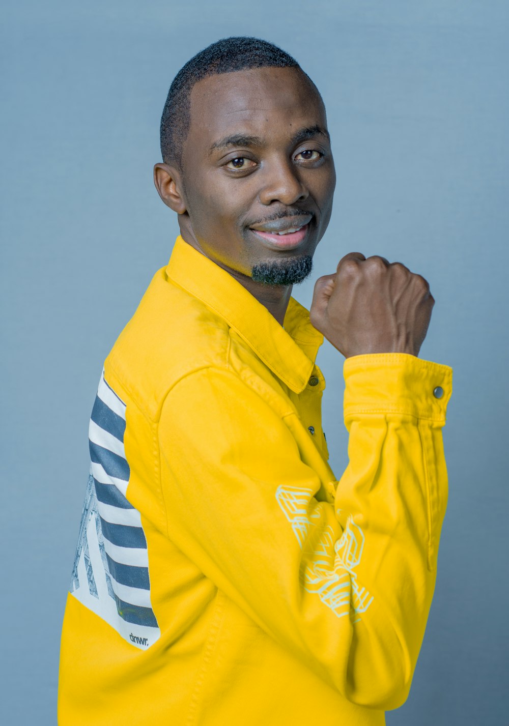 a man in a yellow jacket posing for a picture