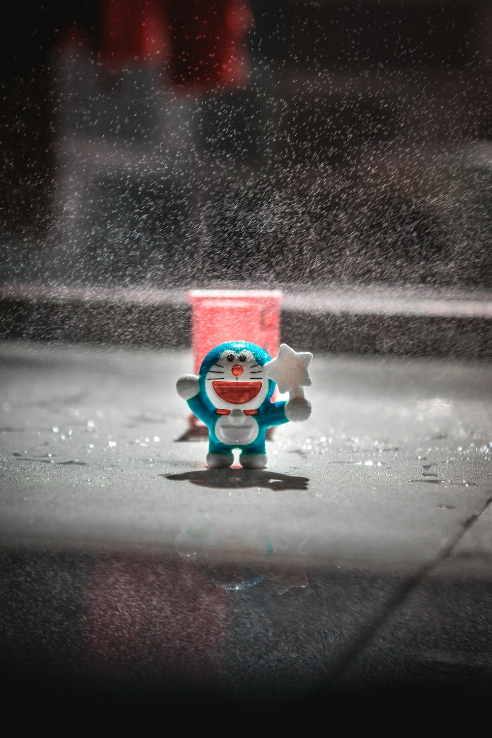 a small toy sitting on the ground in the rain