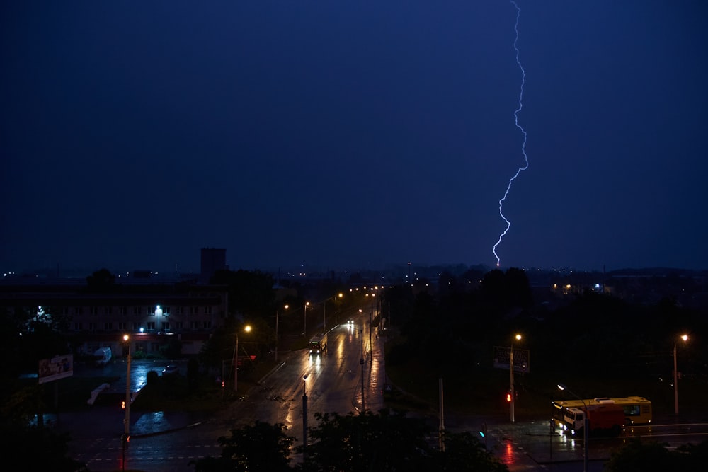 a lightning strikes over a city street at night