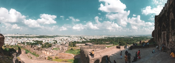 A panoramic view of a lost heritage fort surrounded by lush greenery under a clear sky.
