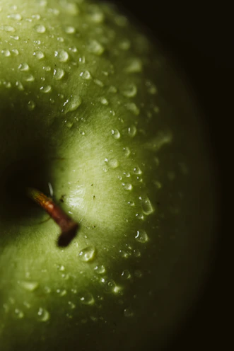 a green apple with water droplets on it