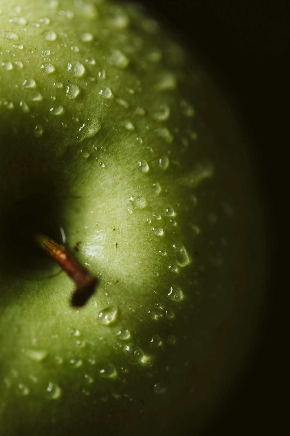 a green apple with water droplets on it