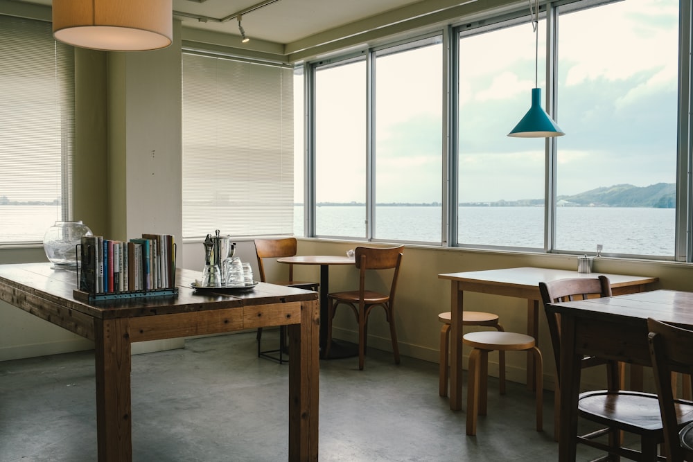 a table and chairs in a room with large windows