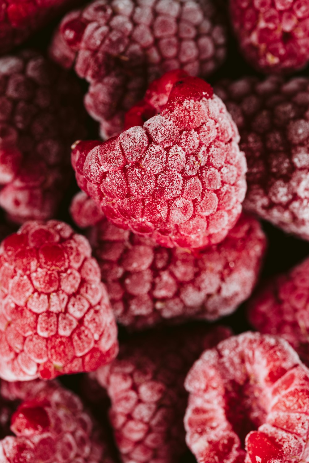 a pile of raspberries covered in powdered sugar