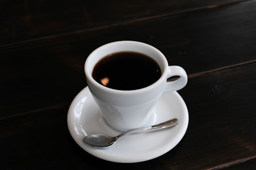 a cup of coffee on a saucer with a spoon