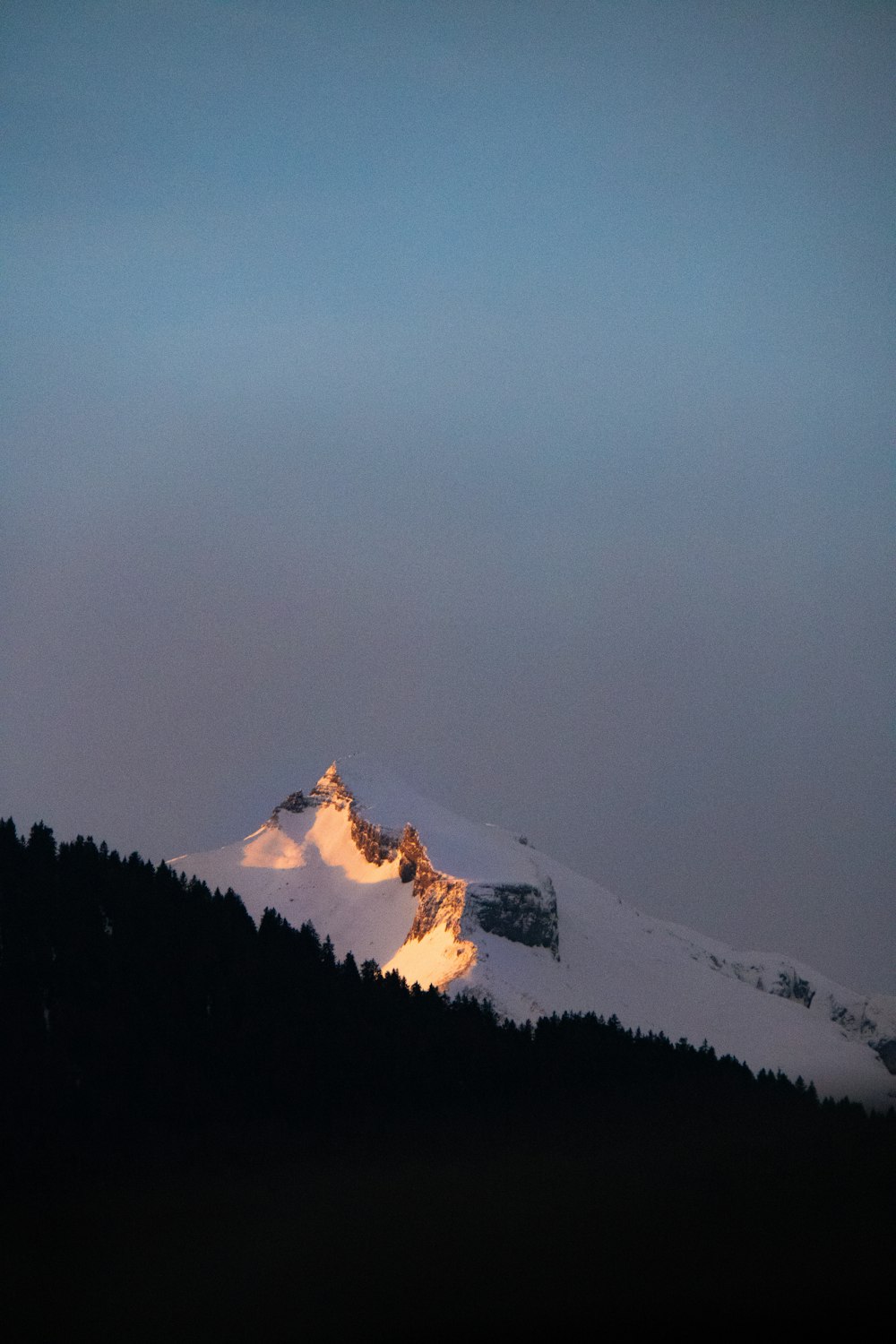 ein schneebedeckter Berg mit einem Licht, das darauf scheint