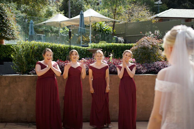 Bridesmaids sharing a candid moment, their dresses flowing in the breeze.