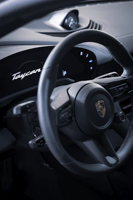 Close-up of Porsche Taycan Turbo S dashboard with illuminated controls