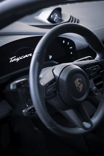 Close-up of Porsche Taycan Turbo S dashboard with illuminated controls