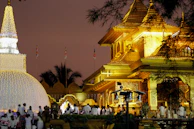 Evening aarti at Vishnupad Temple glowing with saffron and gold lights.