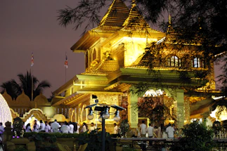 A serene temple entrance adorned with glowing diya lamps at dusk.