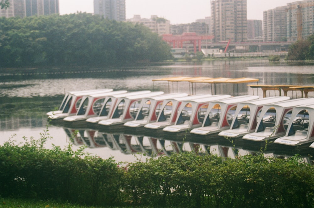 a row of boats sitting on top of a lake