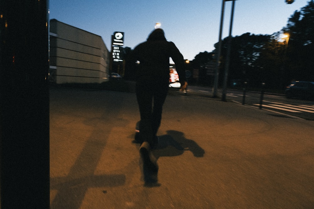 a man riding a skateboard down a street at night