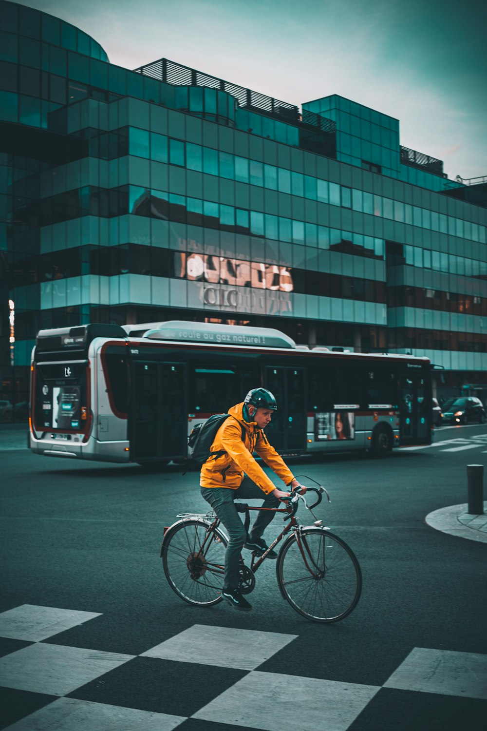 a man riding a bike down a street next to a bus