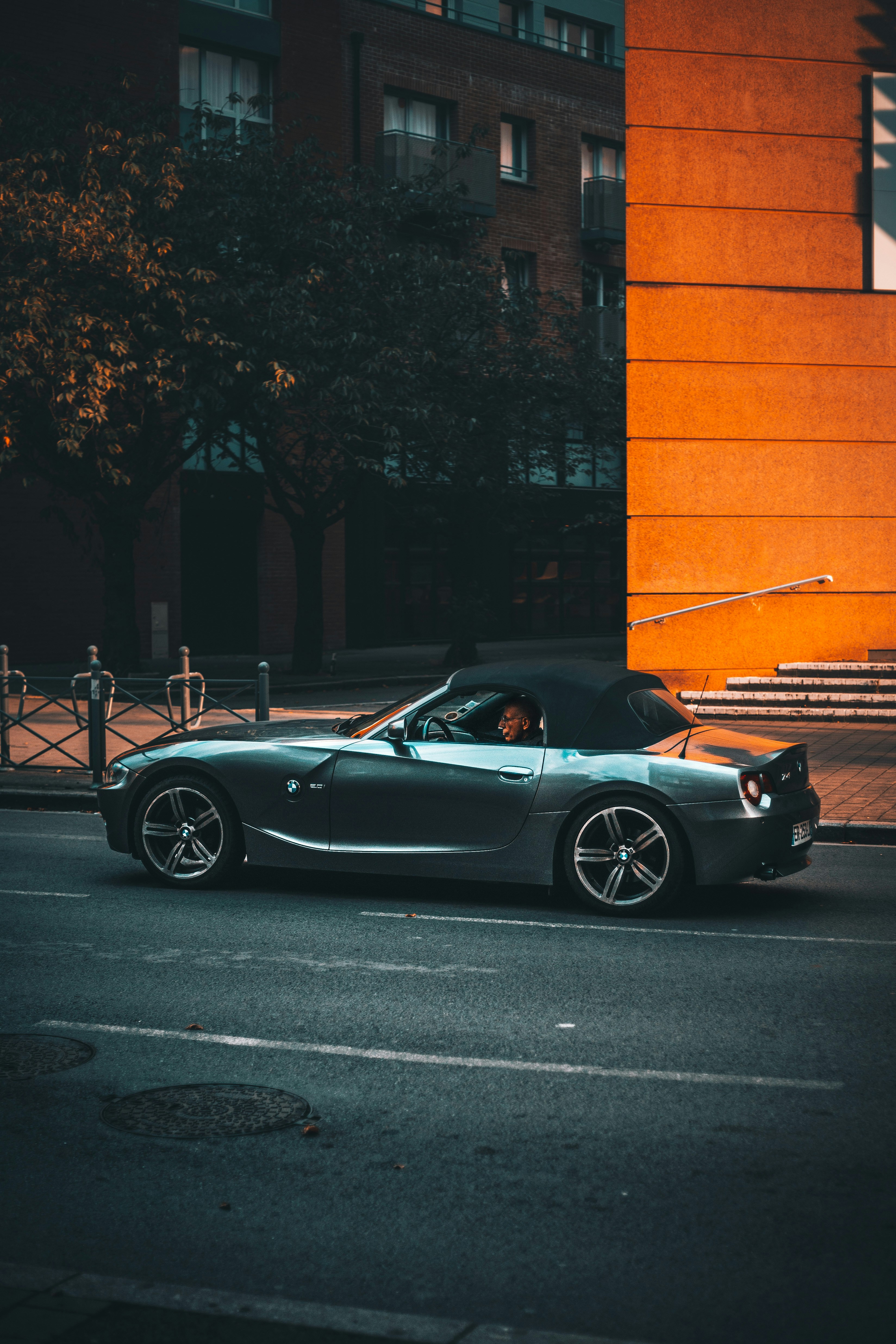 Man in his BMW car in the city with an orange background