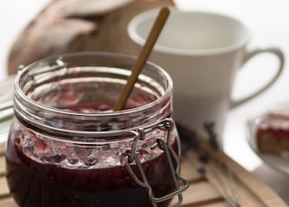 a jar of jam sitting on top of a wooden cutting board