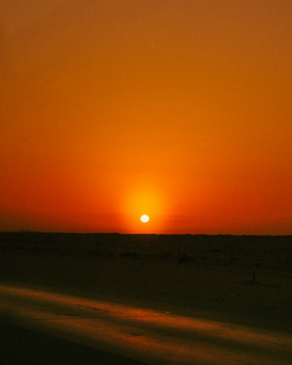 the sun is setting over the horizon of the desert