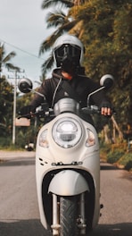 a man riding on the back of a white motorcycle
