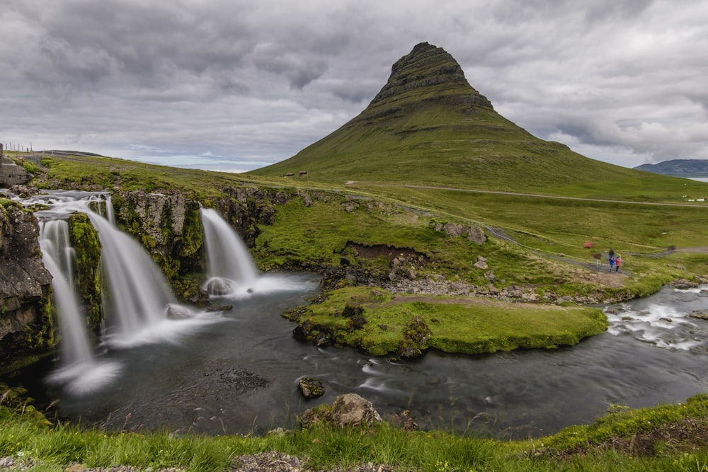 a man standing at the base of a waterfall